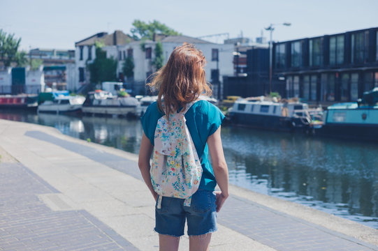 Young woman standing by canal