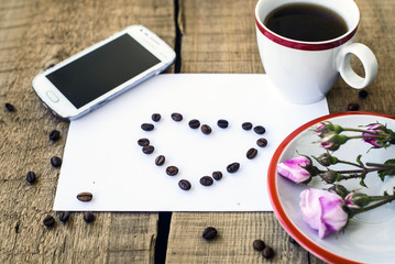 coffee cup, sheet of paper with heart, roses and mobile phone