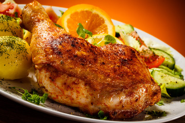 Barbecued chicken leg with boiled potatoes and vegetables