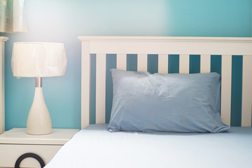 light blue pillow on white  bed in bedroom