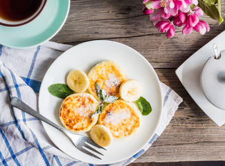 pancakes from cottage cheese  with banana, powdered sugar and mi