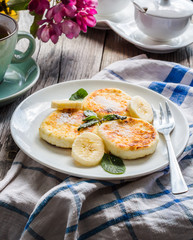 pancakes from cottage cheese  with banana, powdered sugar and mi