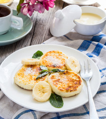 pancakes from cottage cheese  with banana, powdered sugar and mi