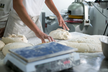 Baker Tossing Flour on Raw Dough