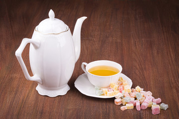 Tea in a white cup and saucer, a scattering of Turkish Delight