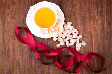 Tea in a white cup and saucer, a scattering of Turkish Delight