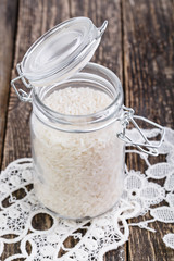 Rice in glass jar on white lace napkin.