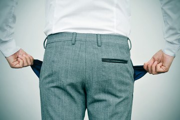 broke businessman showing his empty pockets