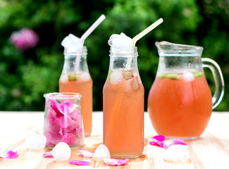 Rhubarb hibiscus iced tea with rose petals in the garden