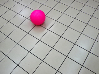 pink ball on white tile