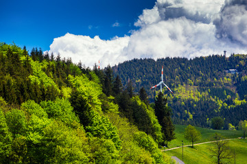 Summer mountain forest landscape with clouds and wind mills. Germany.