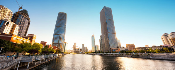 Naklejka premium low angle view of modern skyscrapers and skyline in city at rive