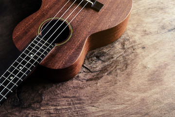 Close up of ukulele on old wood background with soft light - obrazy, fototapety, plakaty