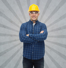 smiling male builder or manual worker in helmet