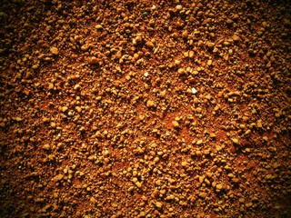 Dry light red crushed bricks surface on outdoor tennis ground. Detail of texture