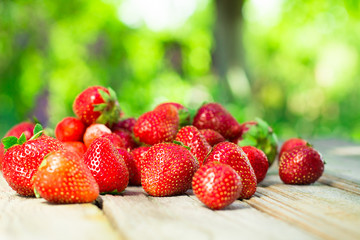 Strawberries in a paper bag on an old wooden background.