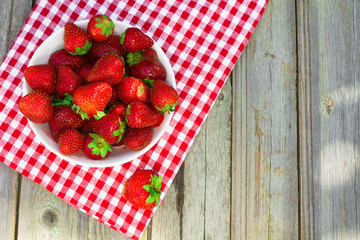 Spring fruits, strawberries on old wooden background.