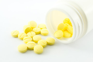 Yellow medicine spilling out of a bottle