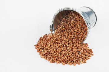 Buckwheat grains spilling out of bucket