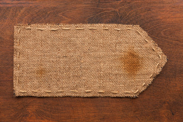 Arrow made of burlap lies on a wooden background
