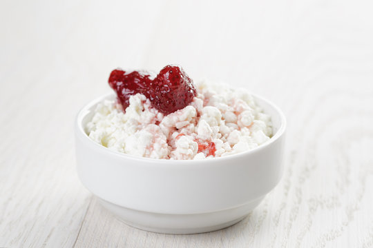 Cottage Cheese With Strawberry Jam In White Bowl On White Wooden