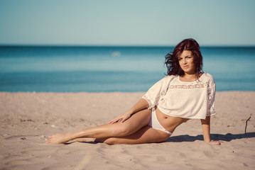 Fototapeta na wymiar Young woman relaxing on the beach near the sea