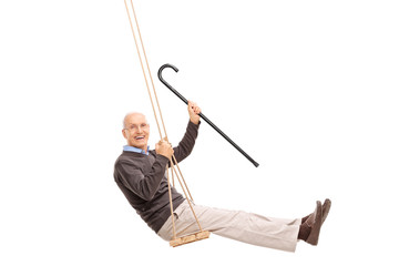 Joyful senior swinging on a swing