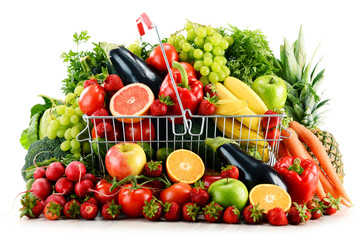 Organic vegetables and fruits in shopping basket on white