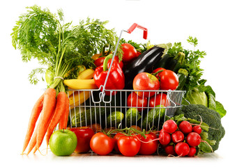 Organic vegetables and fruits in shopping basket on white