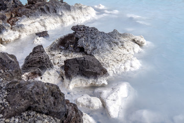 Rocks and warm waters rich in minerals like silica and sulfur in the Blue Lagoon near Reykjavik, Iceland.
