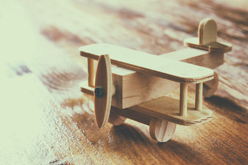 wooden airplane toy over textured wooden background
