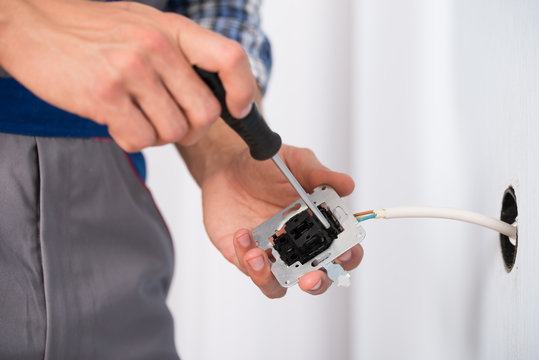 Electrician Hands Installing Socket