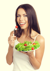 Young woman eating vegetarian salad with cherry tomatoes