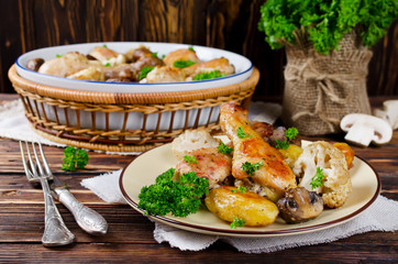 Baked chicken legs with potatoes, champignon and cauliflower