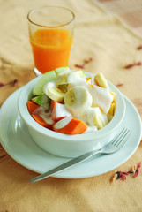 Mixed fresh fruits salad with yogurt and orange juice