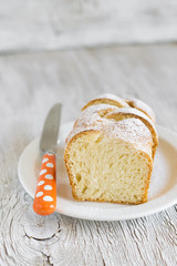 sweet brioche with sugar on a white plate on a light background