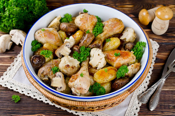 Baked chicken legs with potatoes, champignon and cauliflower