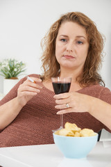 Woman Smoking Cigarette Whilst Drinking Wine And Eating Snacks