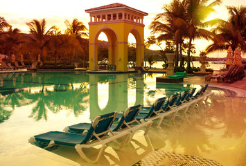 Pavilion on a sunset and the pool with reflection