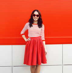 Pretty smiling woman in red sunglasses and dress against the col