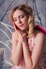 Young beautiful woman in angel costume with pink wings