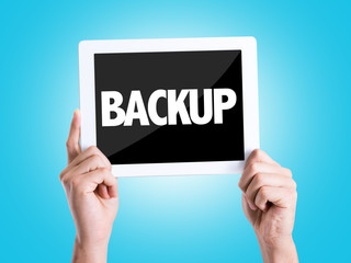 Tablet pc with text Backup with blue background