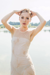 Fototapeta na wymiar Sexy blonde girl posing on the lake shore