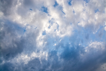 Gray and white clouds on blue sky in windy weather.