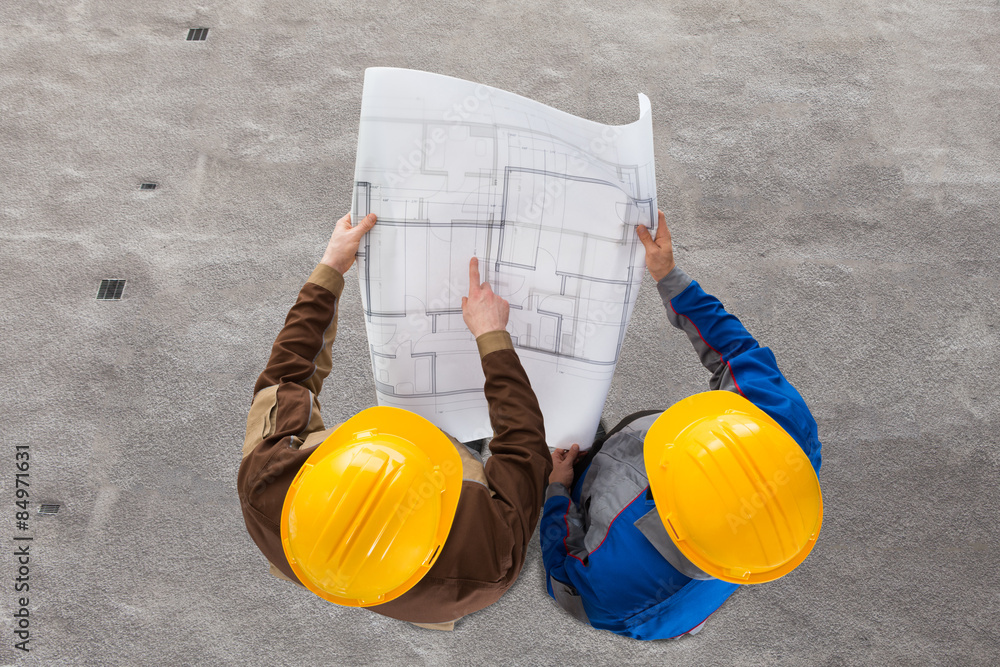 Wall mural two architects discussing blueprint