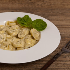 Italian Tortellini Pasta with Alfredo Sauce and Basil. Selective focus.