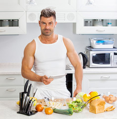 Happy handsome man cooking in kitchen at home.