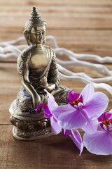 Buddha for spirituality at beauty spa with flower massage and ritual accessories