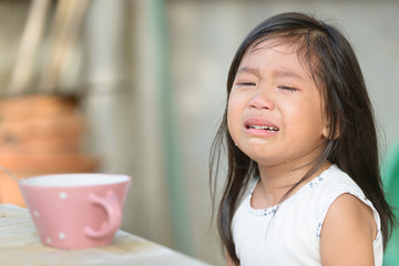 Cute little asian girl crying because don't eat breakfast.