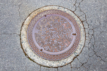 Drain cap art on the surface of sewer cover on the walk way takayama japan